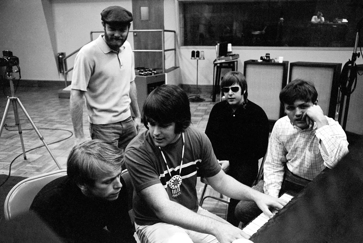 The Beach Boys gathered around a piano in the recording studio